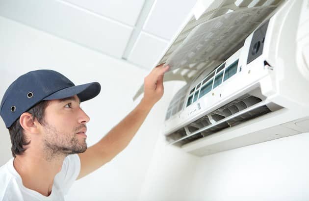 Un professionnel de la climatisation effectue une installation professionnelle d'un climatiseur dans une maison, garantissant un confort optimal pour les occupants